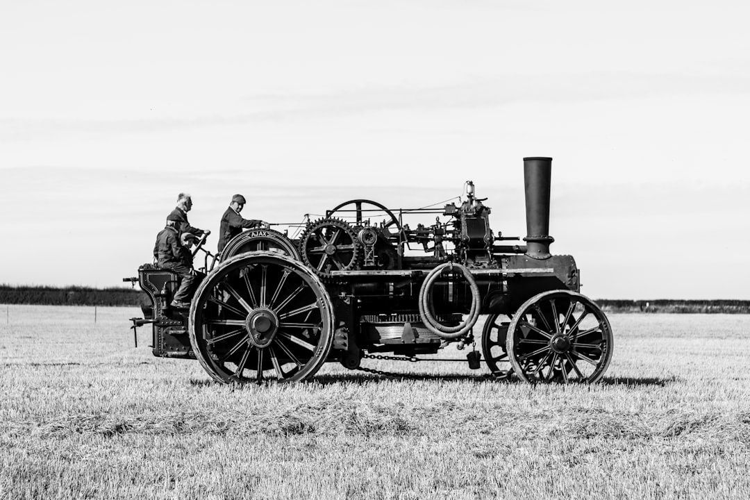Historische Dampfmaschine mit zwei Männern auf einem abgeernteten Feld